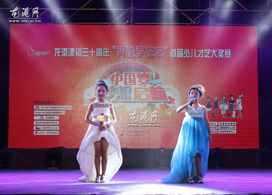 龙港网9月28日讯：昨天晚上，由中共龙港镇委、镇人民政府、苍南县妇联主办的龙港建镇三十周年“阿波罗花艺”才艺大奖赛总决赛在龙跃广场落幕。历时近二个月，经过层层选拔，从200多名节目中脱颖而出的20个节目进行总决赛，展开激烈PK。最终，14号金舞鞋艺校的《小嫚》获得金奖，6号朱昱霖的《红蜻蜓》获得银奖。