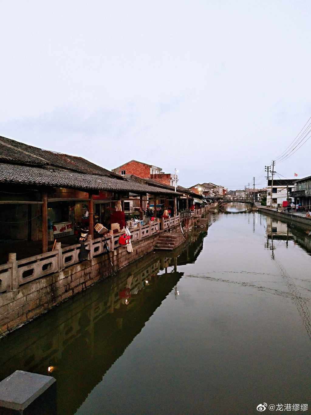 来到龙港象中白沙河边散步，这里都是上世纪留下来的老房子，临河而居的人们看上去也十分悠闲，随手拍了几张照，竟然也拍出了江南水乡的风韵。水波潋影，老墙青瓦，如果再来些杨柳依依的绿色就可以和乌镇相媲美了。 新浪微博 龙港缪缪摄