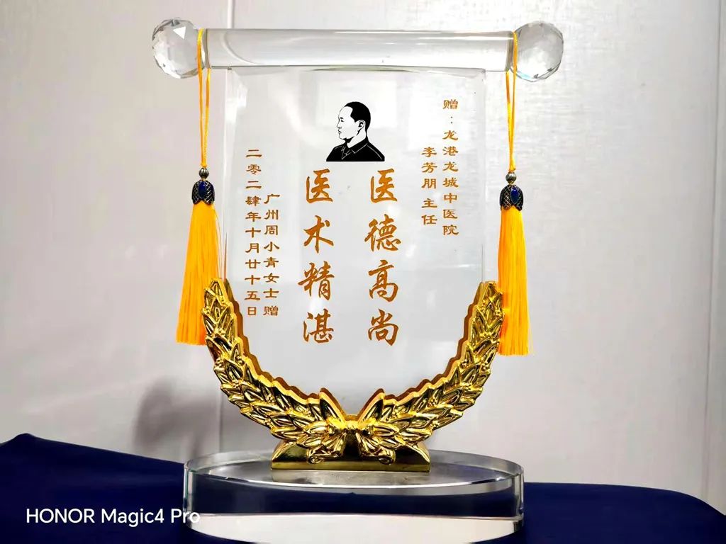 亲手将一枚晶莹剔透的水晶锦旗送到李芳朋主任